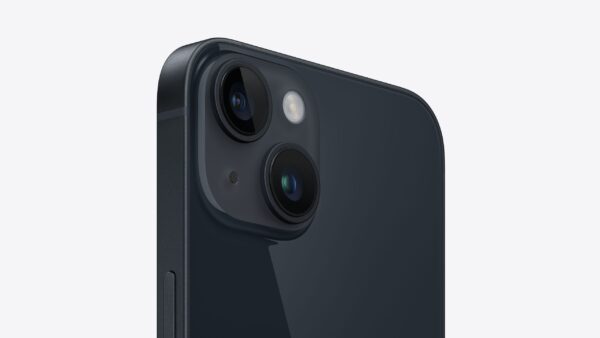 На изображении показана задняя часть телефона, вероятно, Apple iPhone 14 (Midnight), в тёмно-синем цвете. Видны два объектива камеры, расположенные вертикально, а между ними находится вспышка. Сбоку видна металлическая рамка телефона с кнопкой. Задняя панель телефона глянцевая и отражает свет. Фон белый.